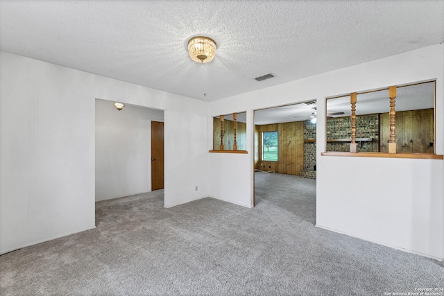 empty room with light carpet and a textured ceiling