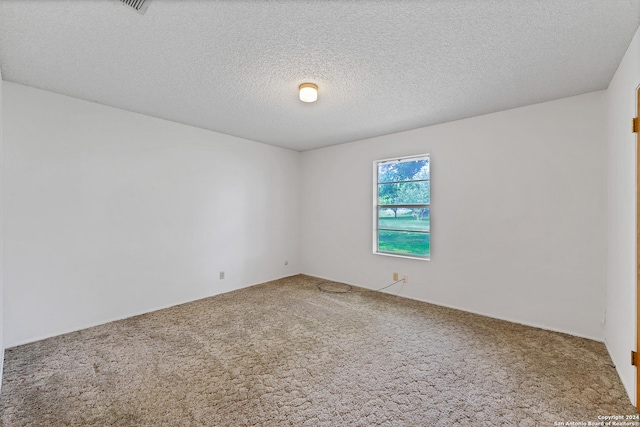 carpeted empty room with a textured ceiling