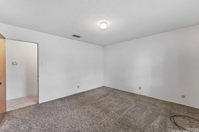 spare room with carpet floors and a textured ceiling