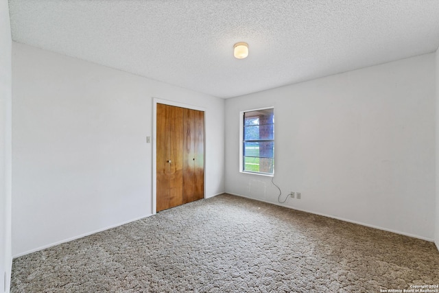 unfurnished bedroom featuring carpet floors, a closet, and a textured ceiling