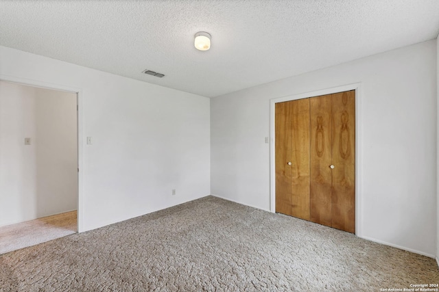 carpeted spare room with a textured ceiling