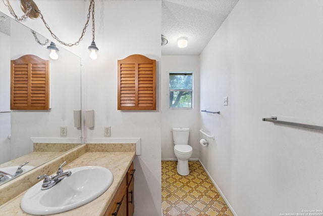 bathroom featuring vanity, toilet, and a textured ceiling