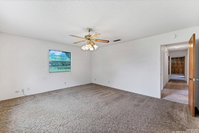 empty room featuring ceiling fan, a textured ceiling, and carpet