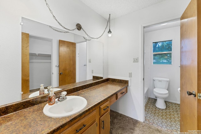 bathroom featuring vanity, a textured ceiling, and toilet