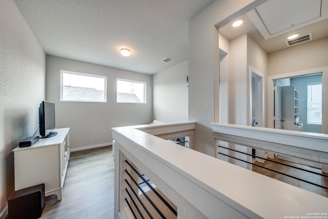 interior space featuring light hardwood / wood-style floors and a textured ceiling