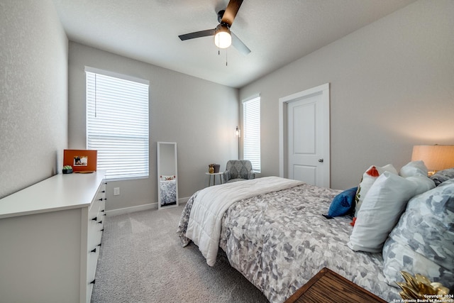 carpeted bedroom with multiple windows and ceiling fan