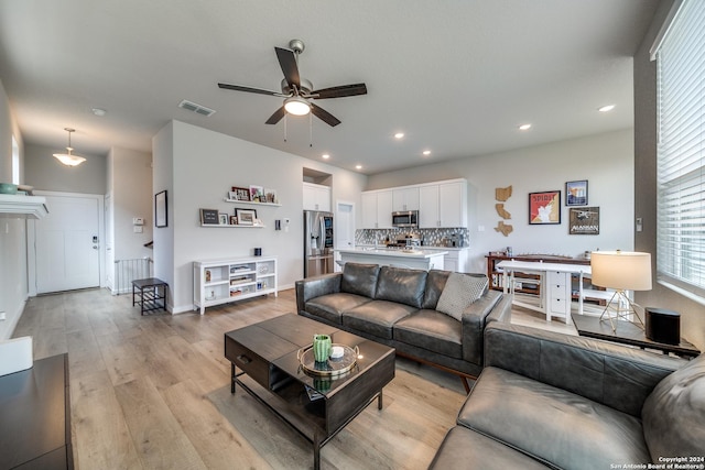 living room featuring light hardwood / wood-style floors and ceiling fan