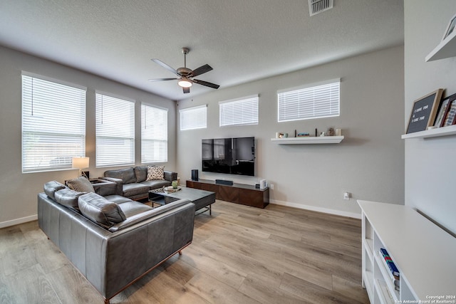 living room featuring ceiling fan, light hardwood / wood-style floors, and a healthy amount of sunlight