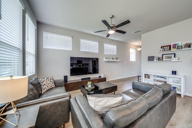 living room featuring a wealth of natural light, ceiling fan, and light hardwood / wood-style flooring