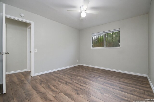 empty room featuring ceiling fan and dark hardwood / wood-style flooring