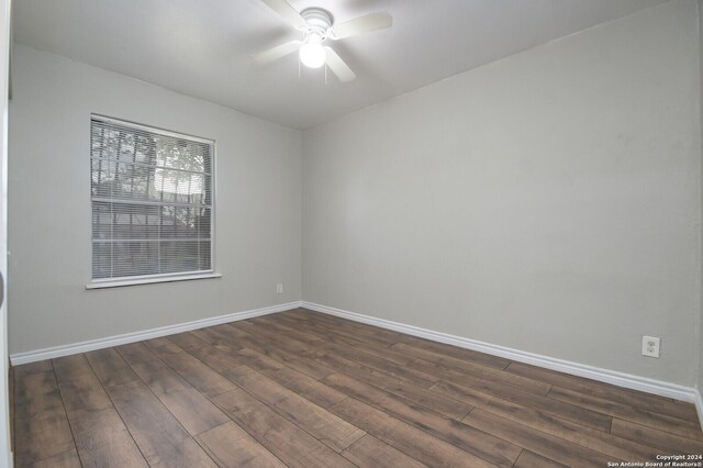 empty room featuring ceiling fan and dark hardwood / wood-style flooring