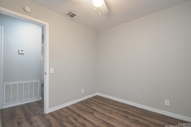 unfurnished room featuring ceiling fan and dark wood-type flooring