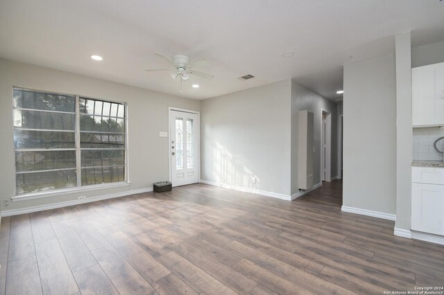 unfurnished living room featuring wood-type flooring and ceiling fan