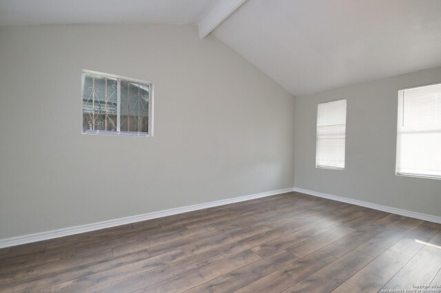 empty room with vaulted ceiling with beams and dark hardwood / wood-style floors