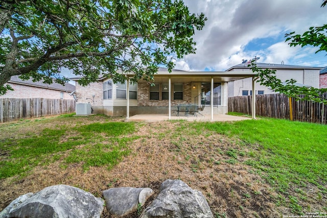 rear view of property featuring a patio area, a yard, and central AC unit