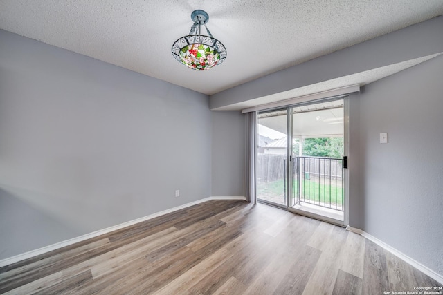 empty room with a textured ceiling and hardwood / wood-style flooring