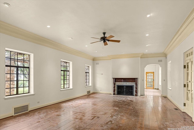 unfurnished living room featuring crown molding, light hardwood / wood-style flooring, a tile fireplace, and ceiling fan