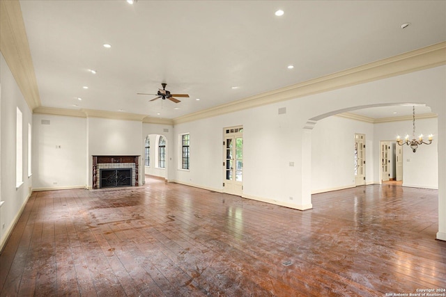 unfurnished living room with a tiled fireplace, crown molding, dark hardwood / wood-style floors, and ceiling fan