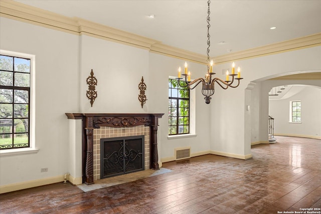 unfurnished living room featuring a tiled fireplace, hardwood / wood-style flooring, and ornamental molding