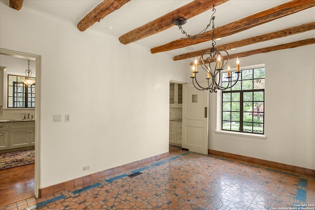 spare room with an inviting chandelier, sink, and beamed ceiling