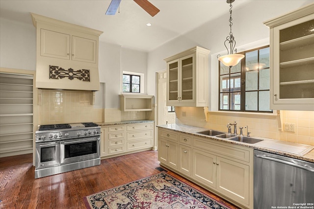 kitchen with decorative light fixtures, sink, dark hardwood / wood-style flooring, stainless steel appliances, and cream cabinets