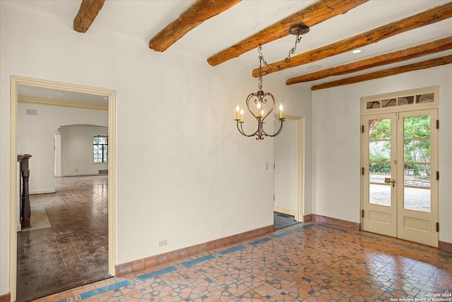 empty room featuring french doors, beam ceiling, and a notable chandelier