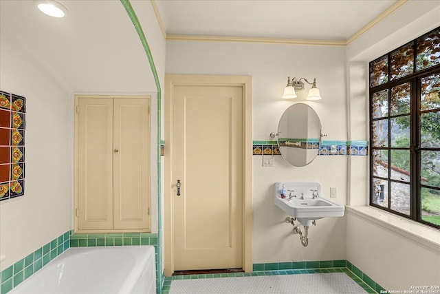 bathroom with crown molding, a tub, and tile patterned floors