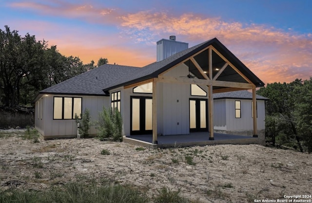 back house at dusk with a patio area