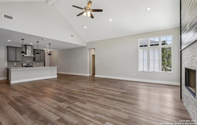 unfurnished living room with ceiling fan, beamed ceiling, high vaulted ceiling, and dark wood-type flooring