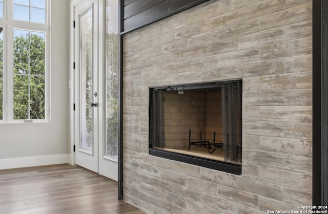 room details with wood-type flooring and a tiled fireplace