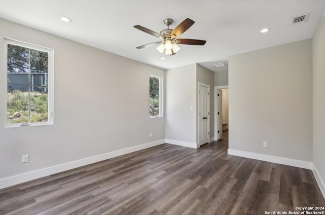 unfurnished room with ceiling fan and dark wood-type flooring