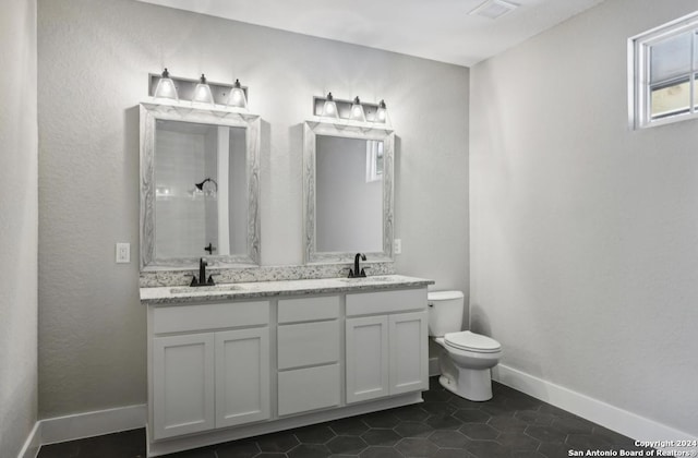 bathroom featuring tile patterned floors, vanity, toilet, and a shower