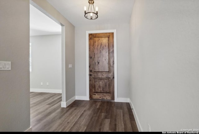 foyer with dark hardwood / wood-style floors and a notable chandelier