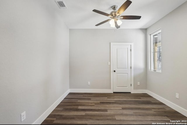 empty room with dark hardwood / wood-style floors and ceiling fan