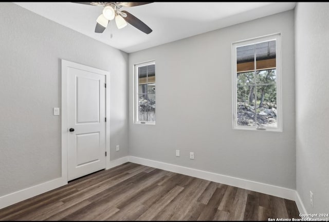 spare room with dark hardwood / wood-style floors and ceiling fan