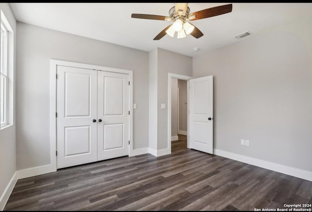 unfurnished bedroom featuring ceiling fan, dark hardwood / wood-style floors, and a closet