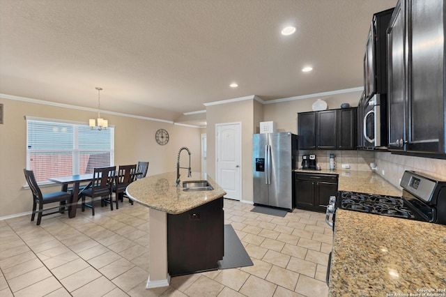 kitchen with pendant lighting, a center island with sink, sink, light stone countertops, and stainless steel appliances