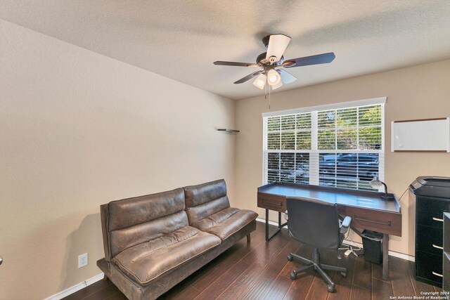 office area with a textured ceiling, ceiling fan, and dark wood-type flooring