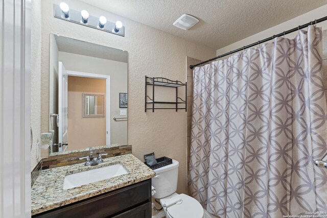 bathroom featuring vanity, a textured ceiling, and toilet