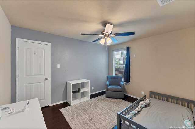 bedroom featuring ceiling fan, dark hardwood / wood-style floors, and a textured ceiling