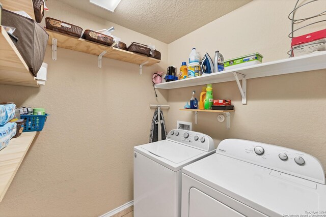 clothes washing area featuring washer and dryer and a textured ceiling