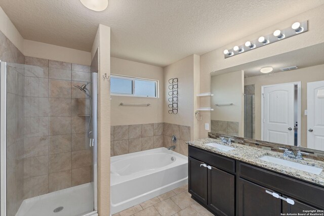 bathroom with tile patterned flooring, vanity, separate shower and tub, and a textured ceiling