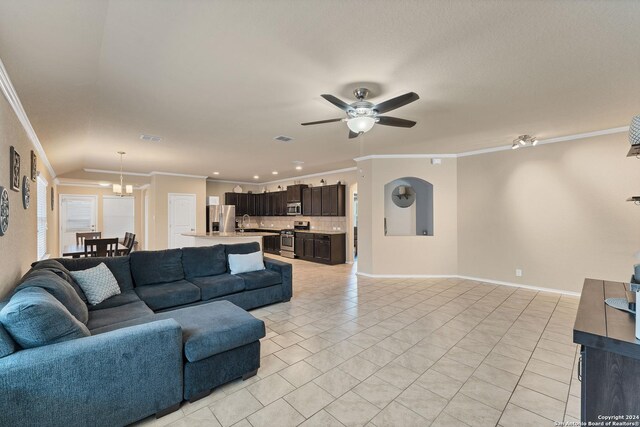 living room with crown molding, sink, light tile patterned floors, and ceiling fan with notable chandelier