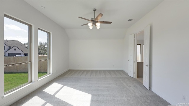 empty room with ceiling fan, light carpet, and vaulted ceiling