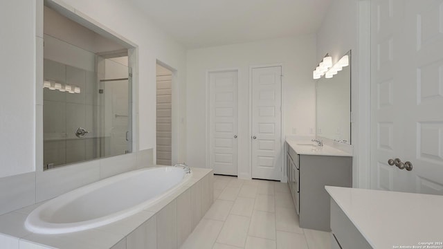 bathroom with plus walk in shower, vanity, and tile patterned flooring