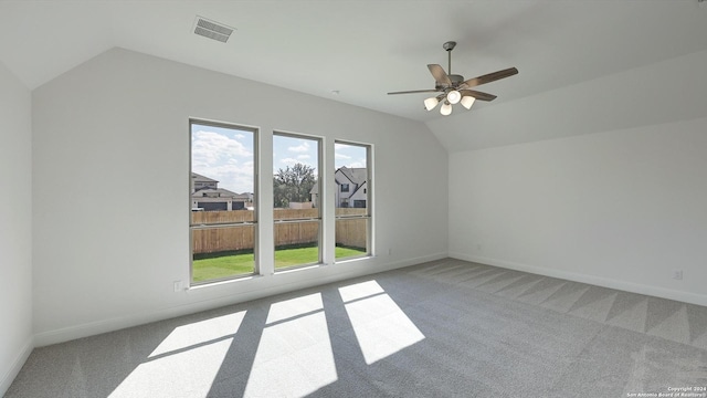 additional living space with carpet, a wealth of natural light, lofted ceiling, and ceiling fan