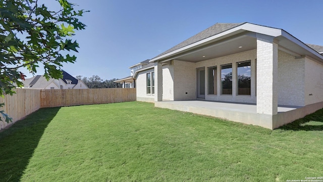 rear view of house with a lawn and a patio