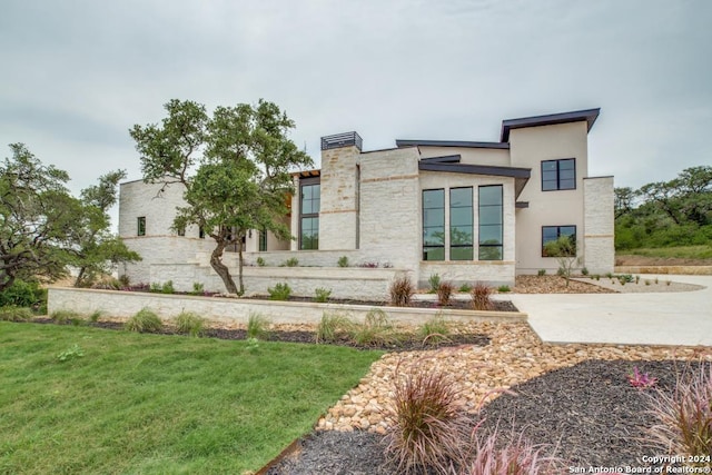 view of front of home featuring stucco siding and a front yard