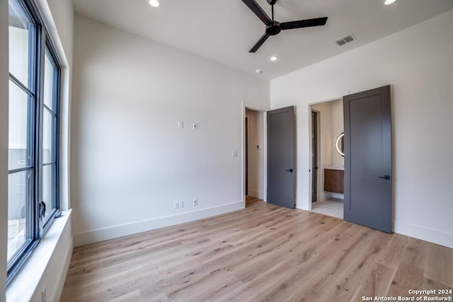 unfurnished bedroom featuring ensuite bathroom, ceiling fan, and light hardwood / wood-style floors