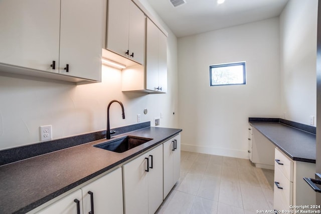 kitchen featuring white cabinetry and sink